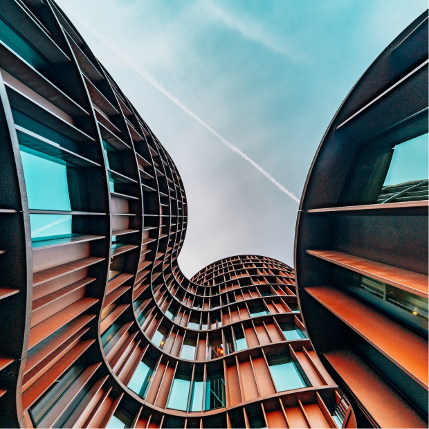 Ground level photo of two buildings with blue sky behind